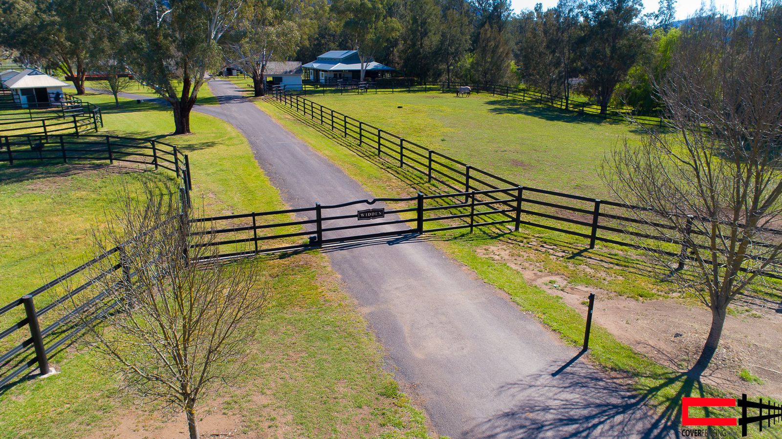 Statement entrance gate with engraved nameplate across a driveway